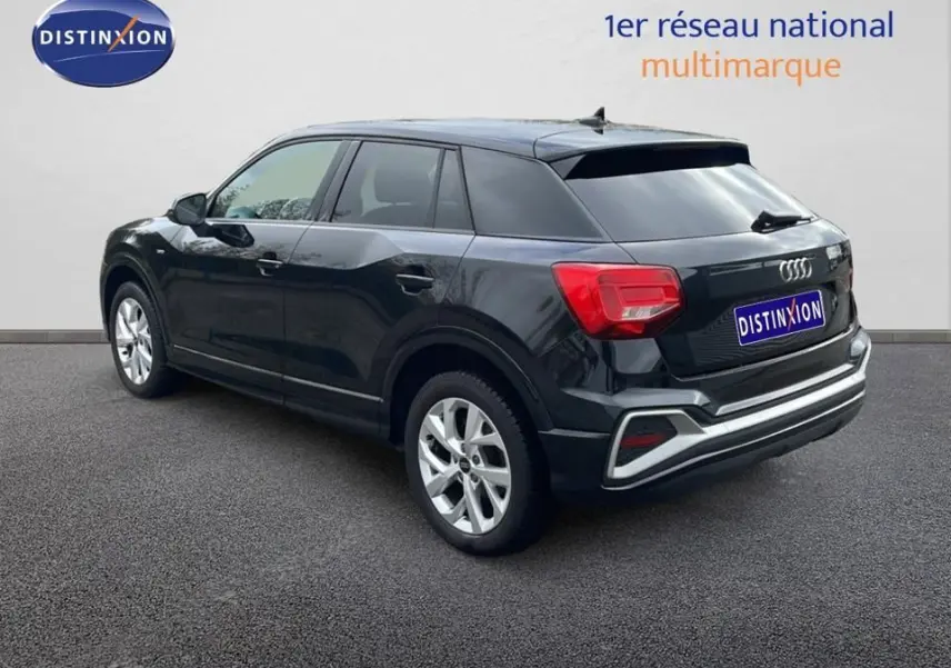 Audi Q2 noir mito métal vue 3/4 arrière côté gauche, avec jantes argentées et feux arrière rouges distinctifs.