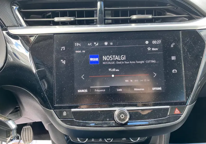 Écran tactile central allumé affichant la radio FM dans l'habitacle noir d'une Opel Corsa 1.2i Turbo 2021.