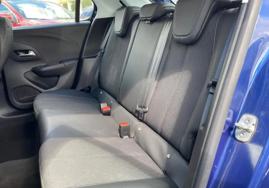 Vue côté droit de la banquette arrière noire de l'Opel Corsa bleu nautique avec ceinture et appuie-têtes visibles.