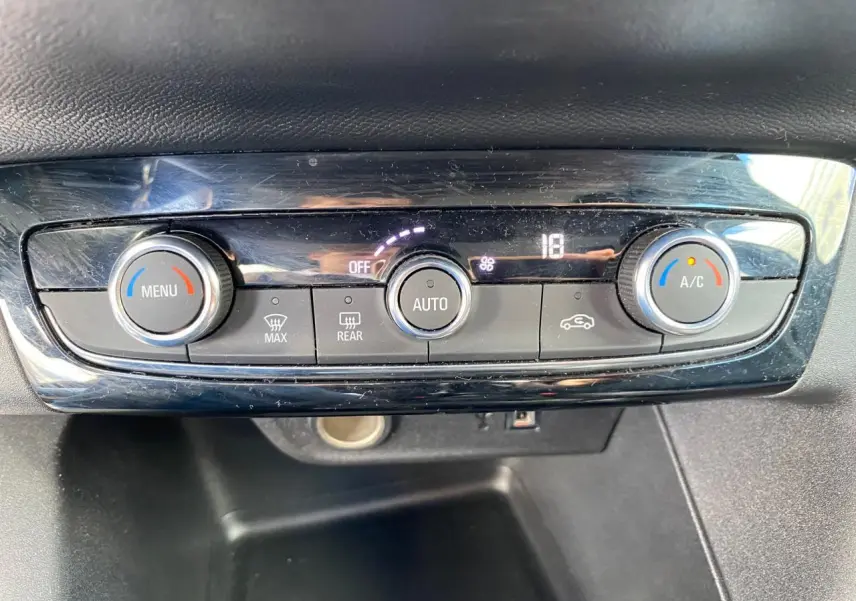 Panneau de commande de la climatisation automatique de l'Opel Corsa bleu nautique, affichant 18 degrés.