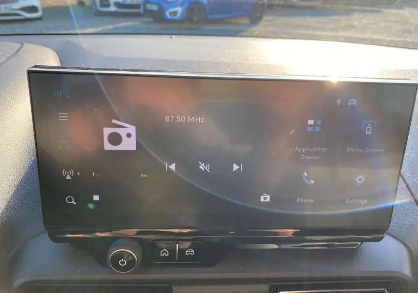 Écran tactile 10 pouces du tableau de bord du Citroën Berlingo 2025, affichant la radio FM et les options connectées.