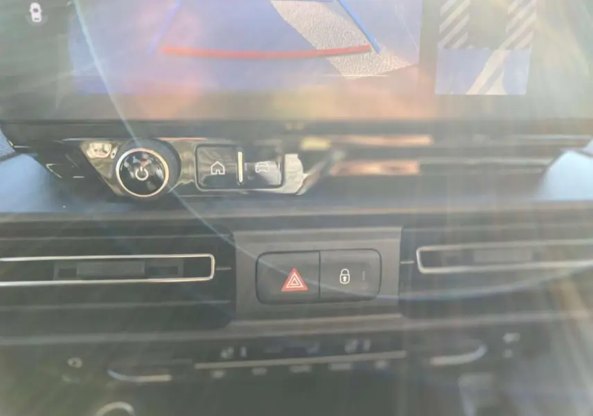 Détail du tableau de bord du Citroën Berlingo 2025 avec commandes de verrouillage et bouton de signalisation d'urgence.
