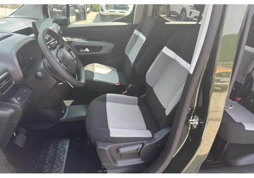 Vue intérieure côté conducteur du Citroën Berlingo 2025 vert Sirka, sièges tissu bicolore gris et noir.