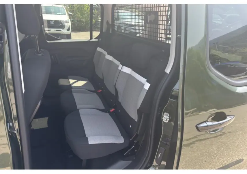 Vue intérieure côté droit du Citroën Berlingo vert Sirka, montrant les sièges arrière en tissu bicolore gris et noir.