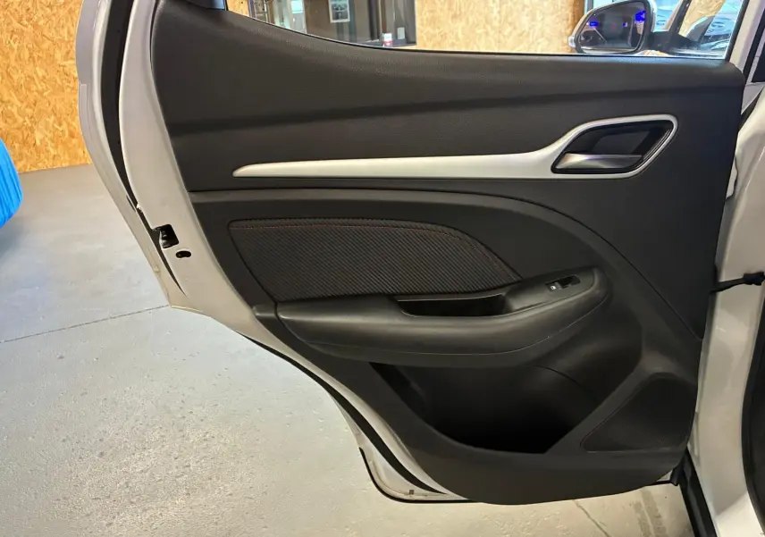 Vue intérieure de la porte arrière droite blanche du MG ZS 2022, avec garniture noire et poignée argentée.