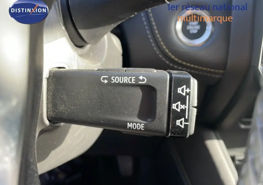 Gros plan sur la commande au volant du mode audio dans l'habitacle du Renault Symbioz gris cassiopée métal.
