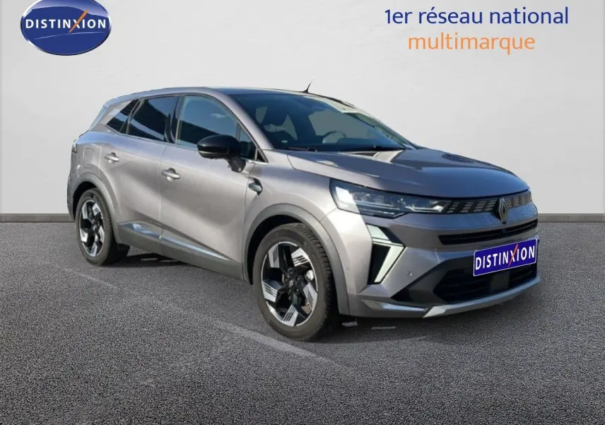 Renault Symbioz gris cassiopée métal en 3/4 avant droit, SUV hybride avec jantes bi-ton et calandre moderne.