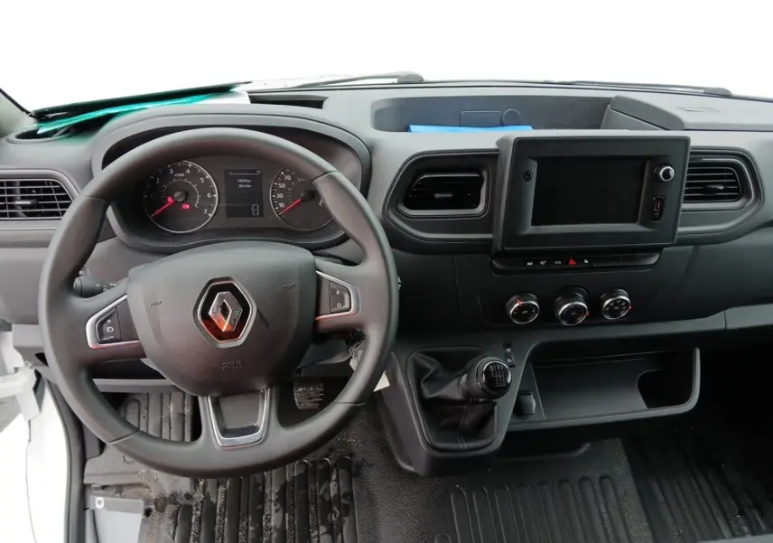 Vue intérieure du tableau de bord du Renault Master 2023, avec volant, levier de vitesses manuel et écran central noir.