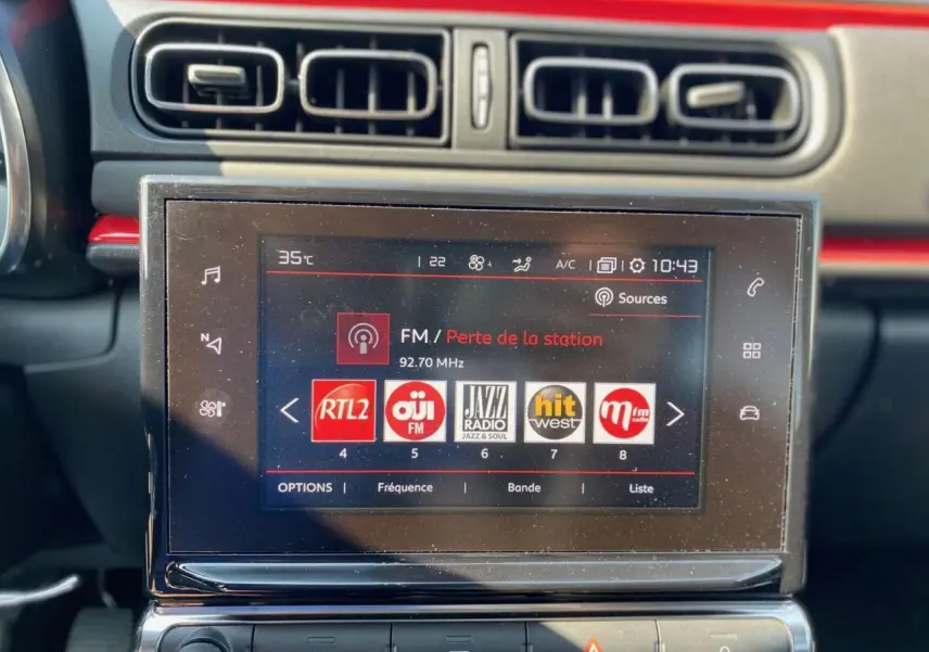Tablette tactile 7 pouces du système CITROËN Connect Nav dans l'habitacle de la C3, avec bandeau orange visible en arrière-plan.