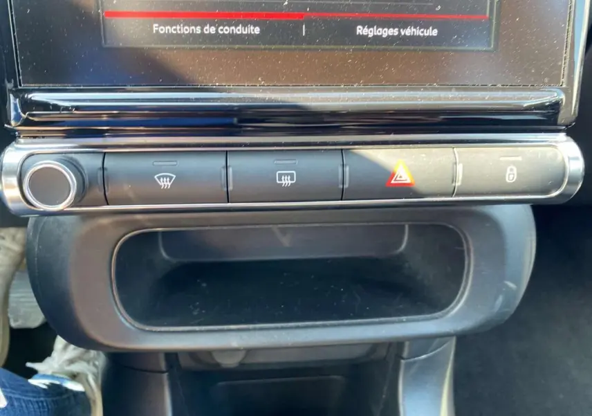 Gros plan sur la console centrale de la Citroën C3 2018, montrant les commandes de climatisation et le bouton de verrouillage.