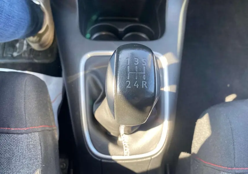 Le levier de vitesses manuel noir de la Citroën C3 2018, entre les sièges avant en tissu noir.