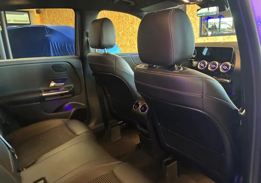 Vue intérieure arrière droite de la Mercedes Classe B 200D Progressive Line 2019 avec sièges tissu gris noir et aérateurs centraux.