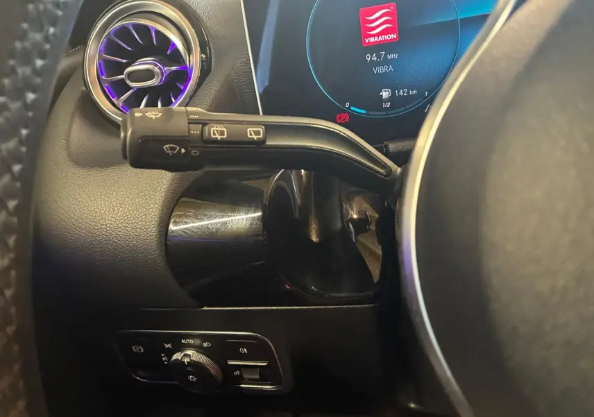 Détail intérieur côté gauche du volant d’une Mercedes Classe B 200D gris, avec commandes d’éclairage et écran digital.