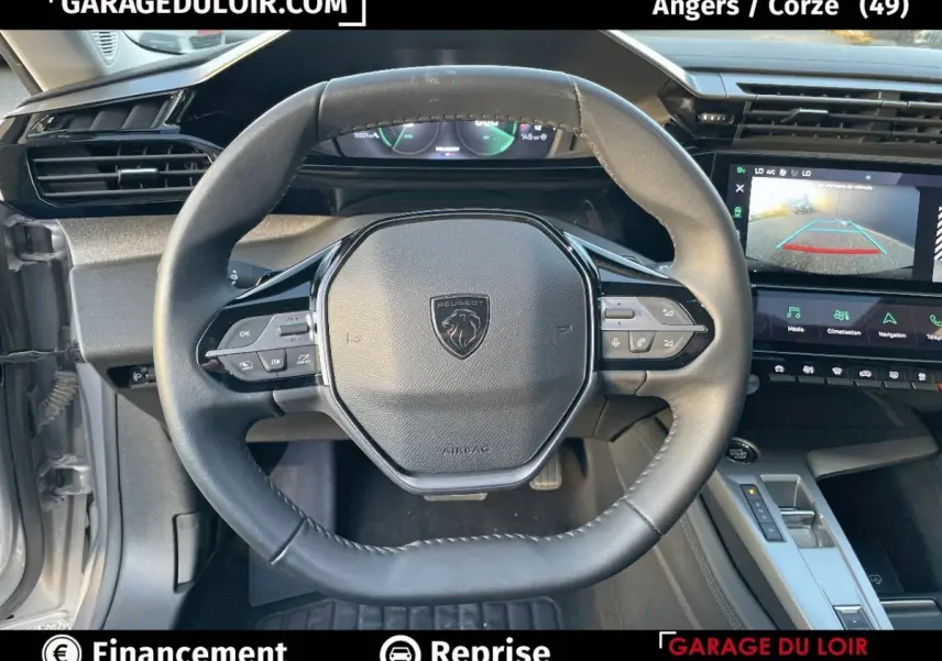 Vue intérieure centrée sur le volant noir de la Peugeot 308 2024, avec tableau de bord numérique et écran tactile visible.