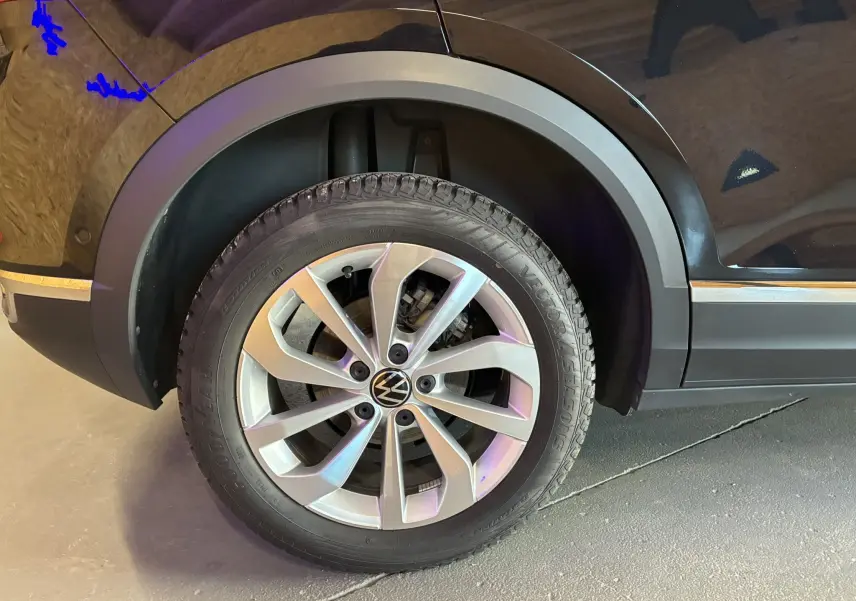 Gros plan sur la roue avant droite du Volkswagen T-Roc noir 2025, mettant en valeur la jante alliage et le pneu Goodyear.