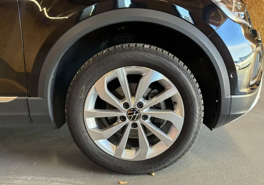 Gros plan sur la roue avant droite d’un Volkswagen T-Roc noir 2025, avec jante alliage argent et pneu Goodyear.