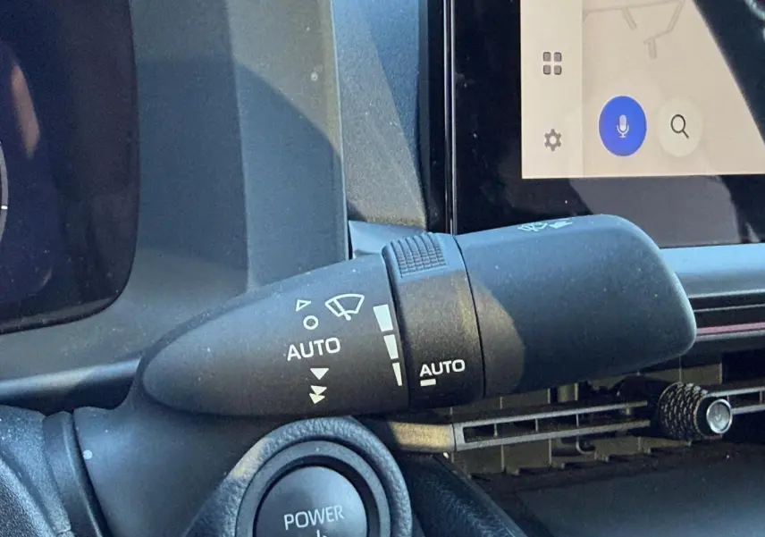 Gros plan sur la commande d'essuie-glace automatique à gauche du volant dans l'habitacle du Toyota C-HR gris Atlas.