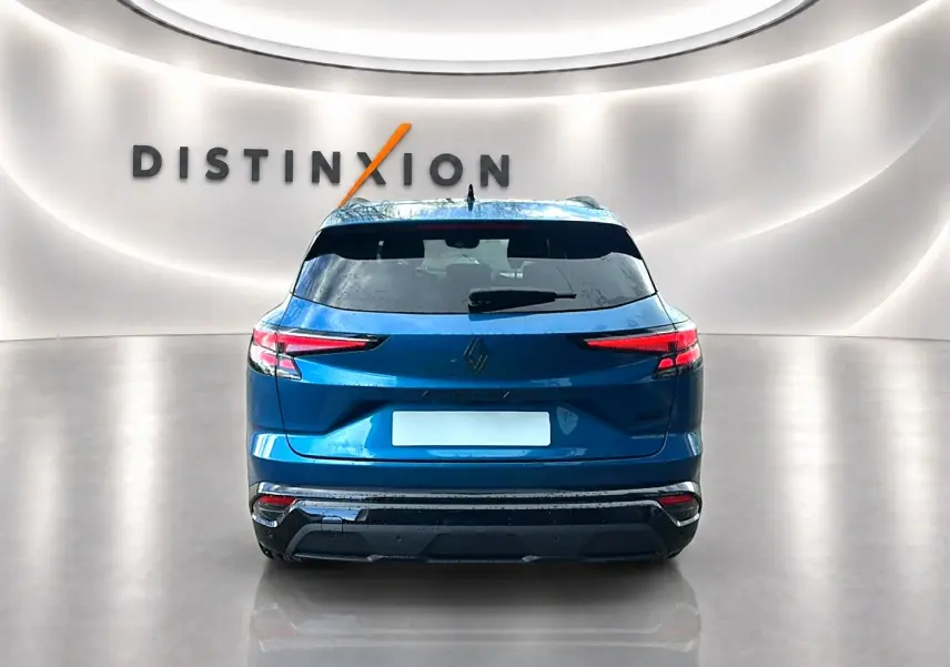Vue arrière d'un Renault Austral bleu outremer avec feux LED étirés et logo Renault centré sur fond clair.