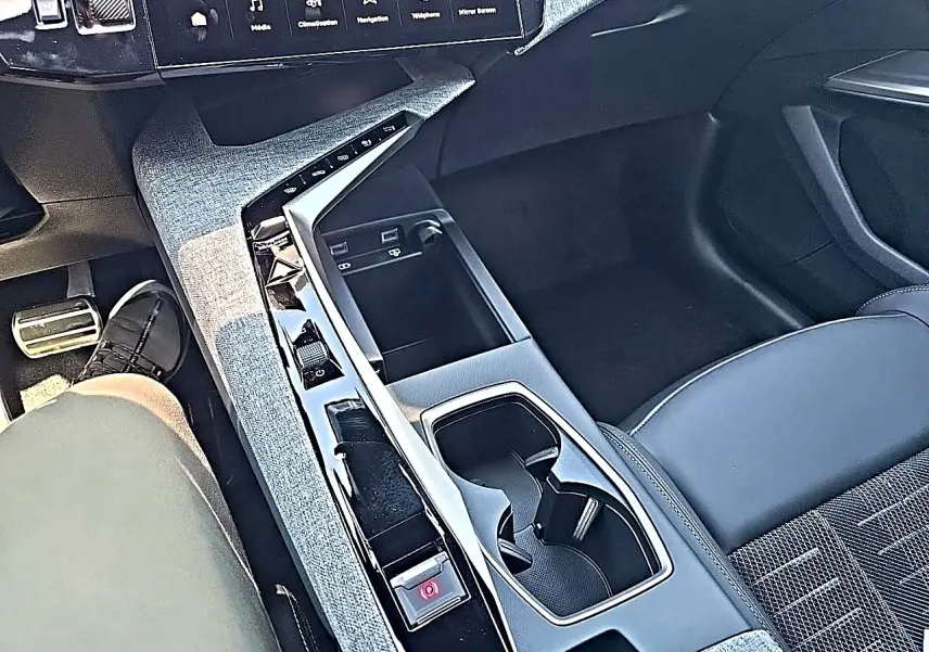 Vue plongeante sur la console centrale noire et grise du Peugeot 3008 1.2 hybrid 145 GT, avec sièges tissu et cuir.