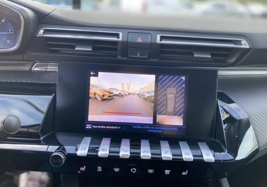 Vue rapprochée de l'écran tactile central affichant la caméra de recul et l'aide au stationnement du Peugeot 508 SW gris Artense.