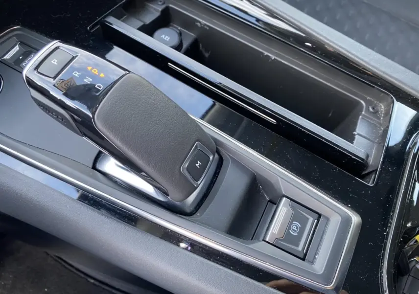 Gros plan sur la commande de boîte automatique et frein de parking électrique dans la console centrale d'une Peugeot 508 SW gris Artense 2021.