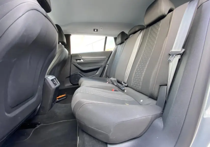 Vue latérale intérieure des sièges arrière noirs de la Peugeot 508 SW gris Artense, montrant l'espace et les ceintures de sécurité.