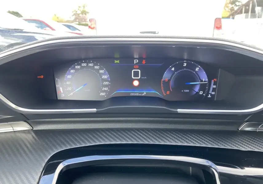 Tableau de bord numérique du Peugeot 508 SW gris Artense, affichant vitesse et compte-tours en vue frontale.
