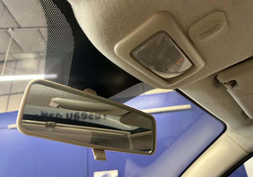 Vue intérieure en gros plan du rétroviseur central et du plafonnier beige du Fiat 500 gris avec toit panoramique.