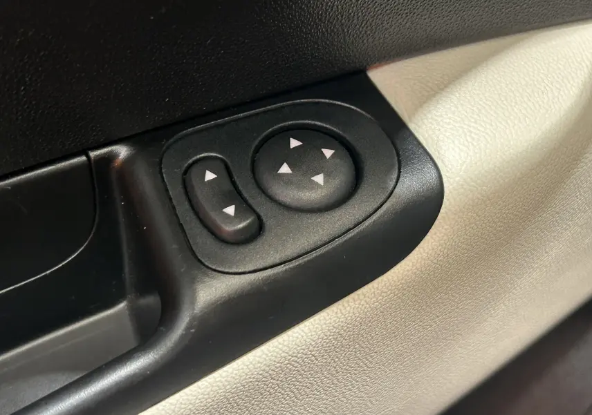 Détail des commandes de réglage des rétroviseurs sur la portière intérieure beige d'une FIAT 500 hybride 2022.