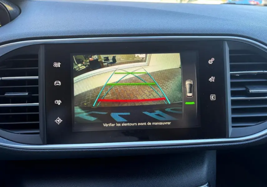 Écran central de la Peugeot 308 Active 2014 noir montrant la caméra de recul avec lignes de guidage colorées.