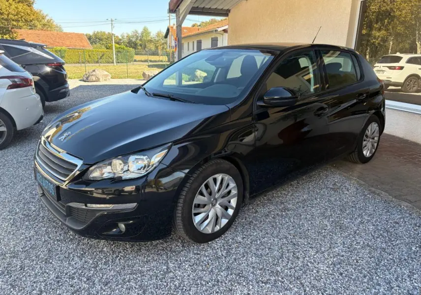 Peugeot 308 Active noire vue en 3/4 avant droit, avec calandre chromée et jantes alliage multibranches.