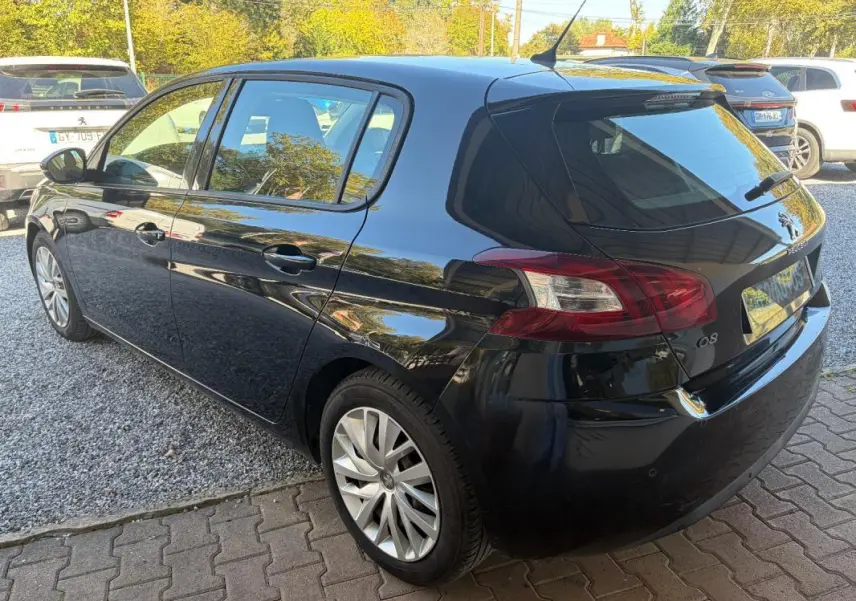 Peugeot 308 Active noire vue en 3/4 arrière droit, avec jantes alliage et feux arrière caractéristiques visibles.