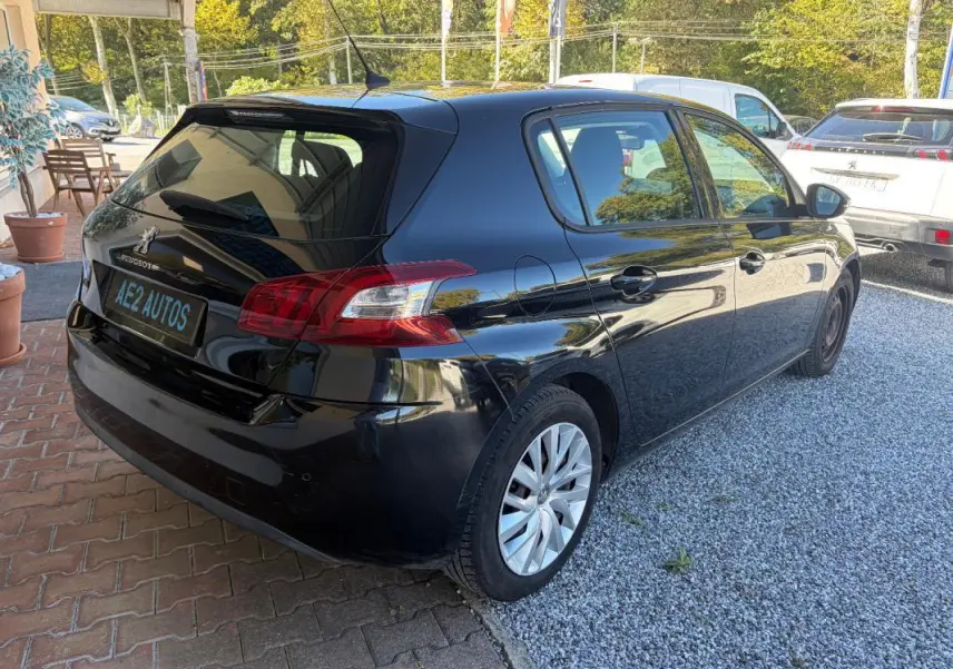 Peugeot 308 Active noire vue en 3/4 arrière droit, avec jantes alliage et plaque AE2 AUTOS visible.