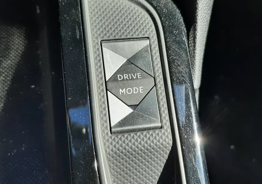 Bouton Drive Mode en gros plan sur la console centrale noire texturée du DS3 Crossback gris foncé 2021.