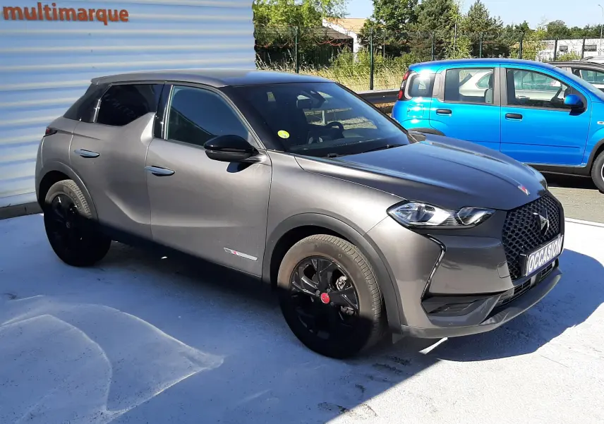 DS3 Crossback gris foncé en 3/4 avant droit, avec jantes noires et calandre distinctive DS visible.