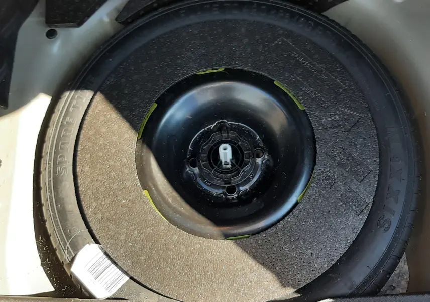Gros plan sur la roue de secours noire dans le coffre d'un DS3 Crossback gris foncé 2021 diesel