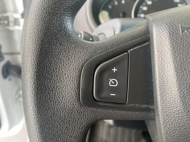 Gros plan sur les commandes de régulateur de vitesse au volant du Renault Kangoo Express blanc 2022.