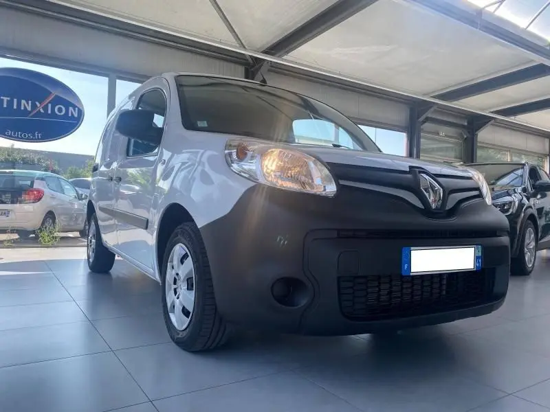 Vue 3/4 avant gauche du Renault Kangoo Express blanc avec pare-chocs noir mat en showroom lumineux.