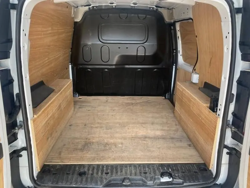 Vue intérieure arrière du Renault Kangoo Express blanc 2022 avec aménagement bois et cloison pleine noire.