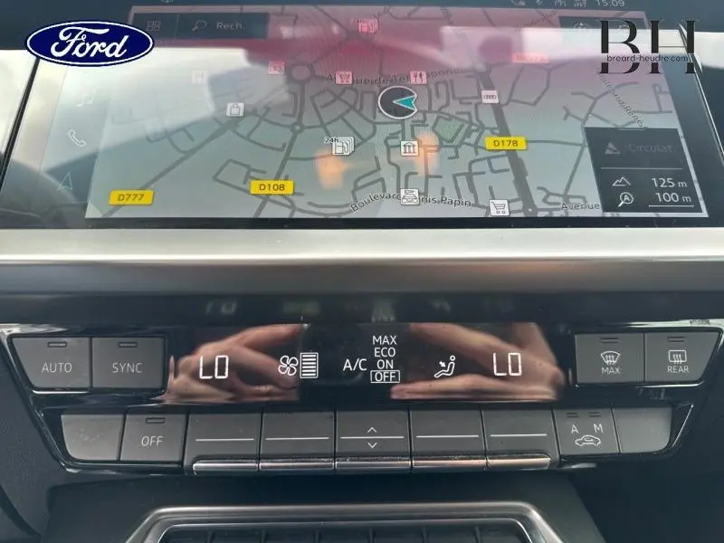Vue rapprochée de l'écran tactile et des commandes de climatisation de l'Audi A3 Sportback noir Mythic métallisé.