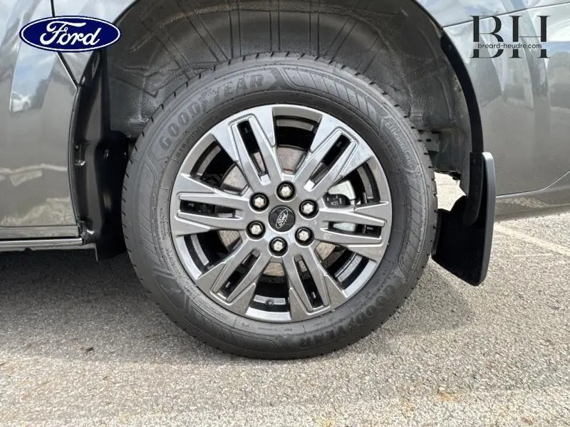 Gros plan sur la roue avant droite du Ford Transit Custom gris Magnetic avec jante alu 6 x 2 branches gris carbone.