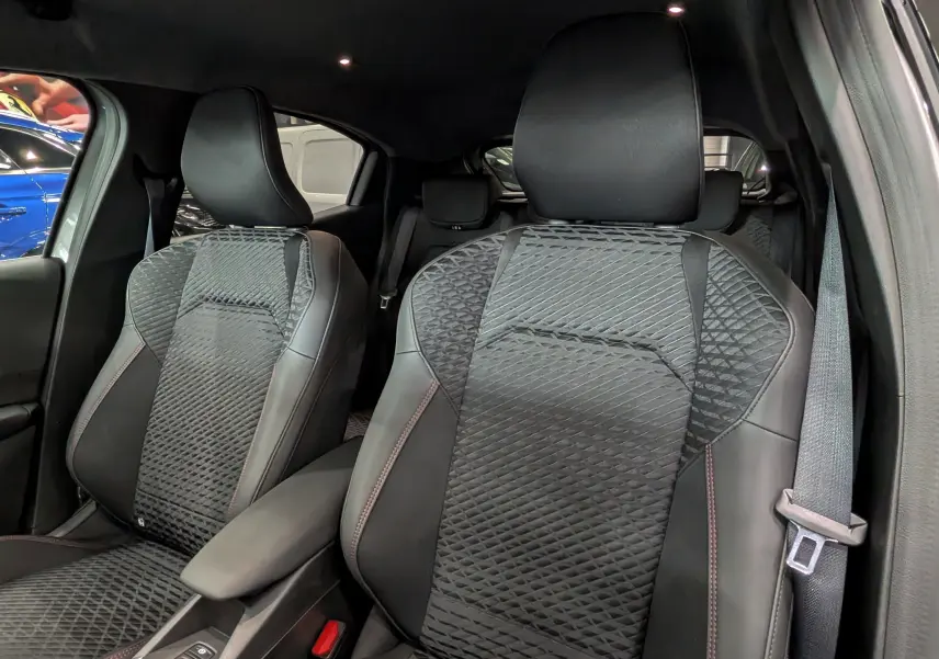 Vue rapprochée des sièges avant en cuir noir avec surpiqûres rouges de la Renault Clio VI TCe 115 CH TECHNO 2026.