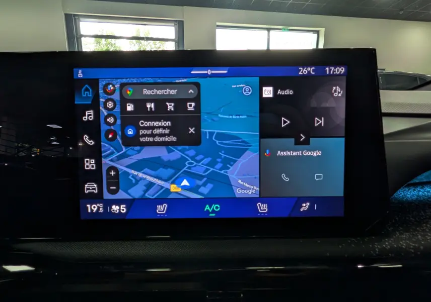 Écran tactile central de la Renault Clio VI TCe 115 Techno affichant la navigation et l'assistant Google, intérieur noir.