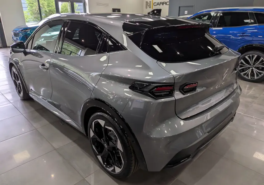 Vue 3/4 arrière droite de la Renault Clio VI TCe 115 Techno gris schiste avec jantes noires bicolores et toit noir.