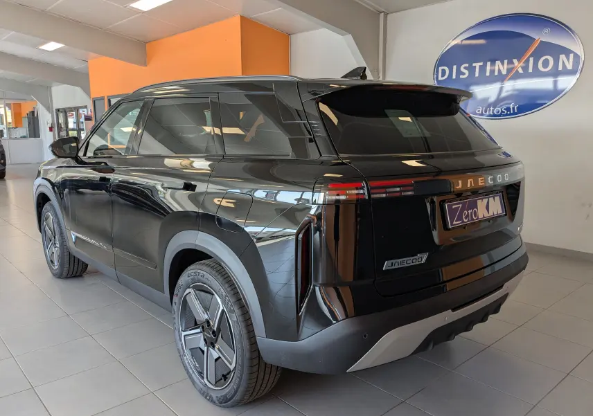 Vue 3/4 arrière droite du JAECOO J7 noir carbone métal, avec feux arrière horizontaux et jantes au design futuriste.