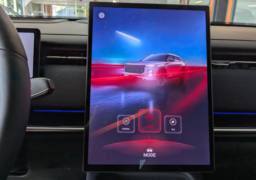 Écran central tactile affichant le mode Sport avec une animation du SUV JAECOO J7 blanc sur fond bleu et rouge, intérieur noir.