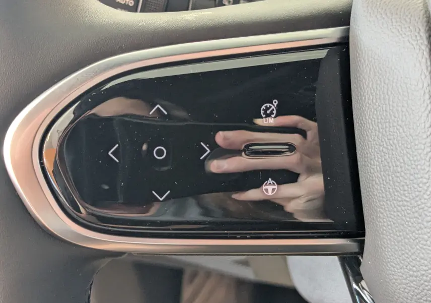 Gros plan sur les commandes noires brillantes au volant du JAECOO J7 1.5 TGDI PHEV 205CH EXCLUSIVE, finition carbone métal.