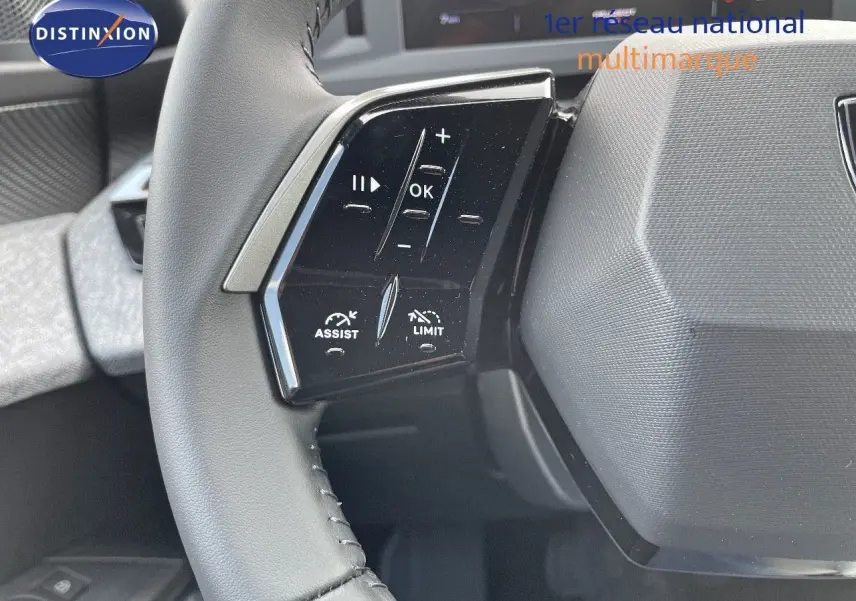 Gros plan sur les commandes au volant noir du Peugeot 3008 Hybrid 2025, avec boutons d'assistance et limitation de vitesse.