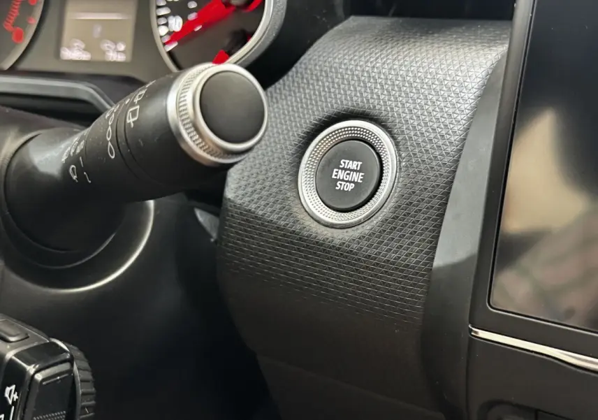 Détail intérieur montrant le bouton Start Engine Stop sur tableau de bord texturé noir de Renault Clio gris clair.