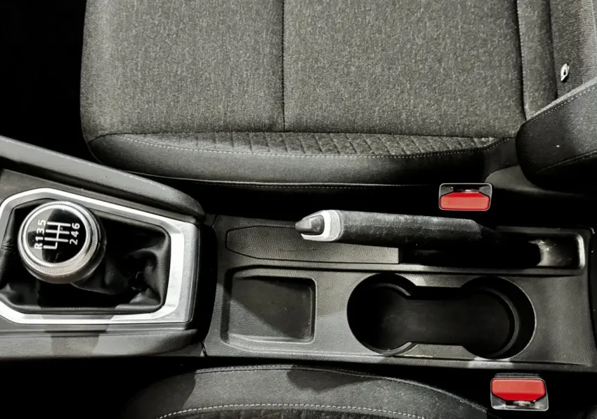 Vue plongeante sur la console centrale de la Renault Clio Business TCe 90 2020, avec levier de vitesse manuel et frein à main noir.